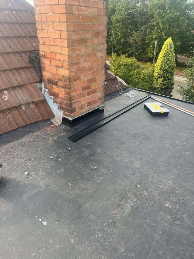 This is a photo of a flat roof which has just been repaired, there is also a chimney stack and some leadwork has also been dressed. Works carried out by East Grinstead Roofing Repairs