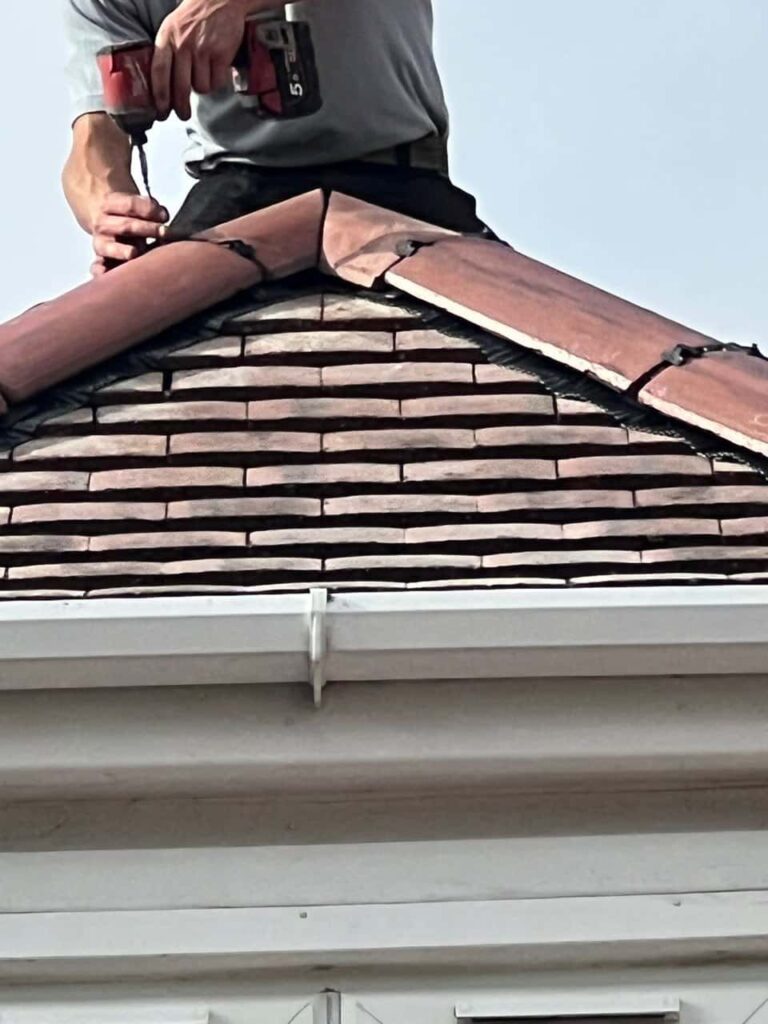 This is a photo of one of the operatives of East Grinstead Roofing Repairs installing new ridge tiles